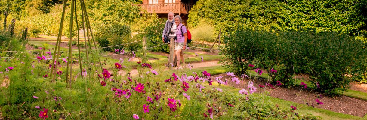 Couple walking around Swiss Cottage Gardens at Osborne House, Isle of Wight